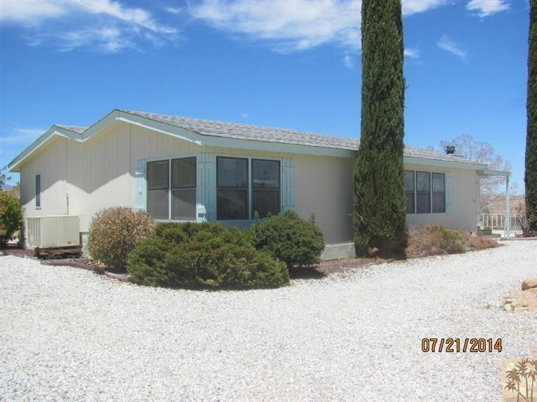 7180 Saddleback Road Joshua Tree, CA 92252 - Photo 1 of 20 a front view of a house with a yard