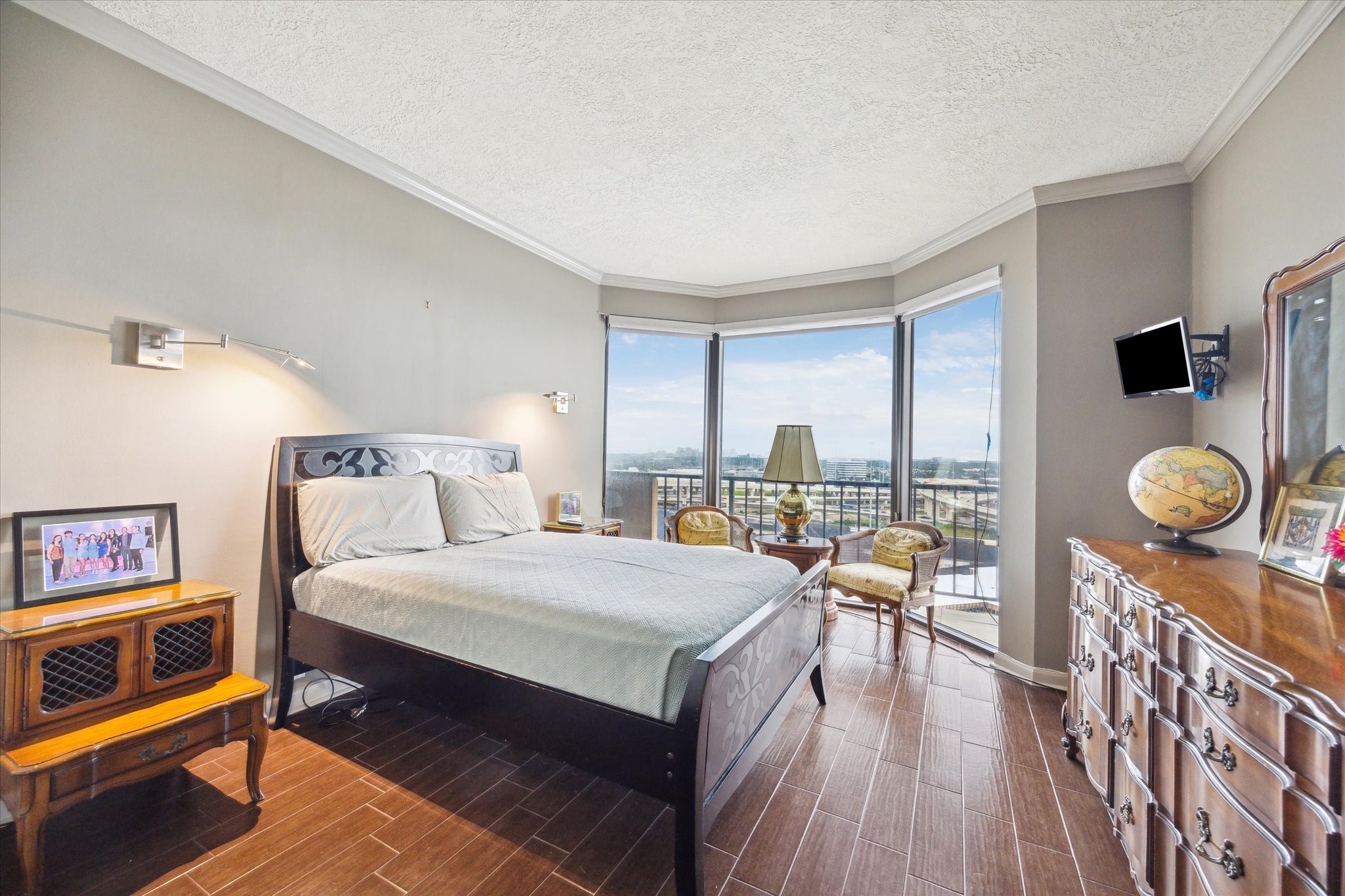 3350 McCue Road, Unit 1504 Houston, TX 77056 - Photo 17 of 32 This spacious secondary bedroom features a wall of windows framing impressive views, crown molding, tile flooring, and built-in reading lights for added comfort.