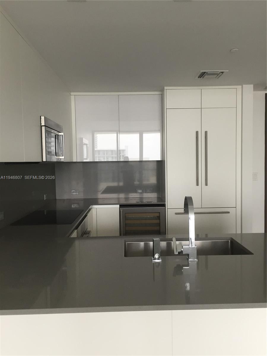 68 Southeast 6th Street, Unit 2504 Miami, FL 33131 - Photo 11 of 47 a kitchen with a sink and cabinets