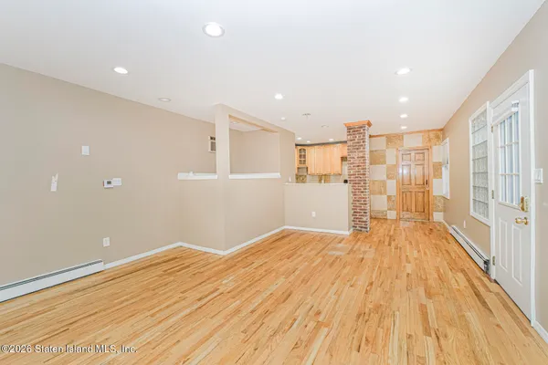 a view of a big room with wooden floor and windows