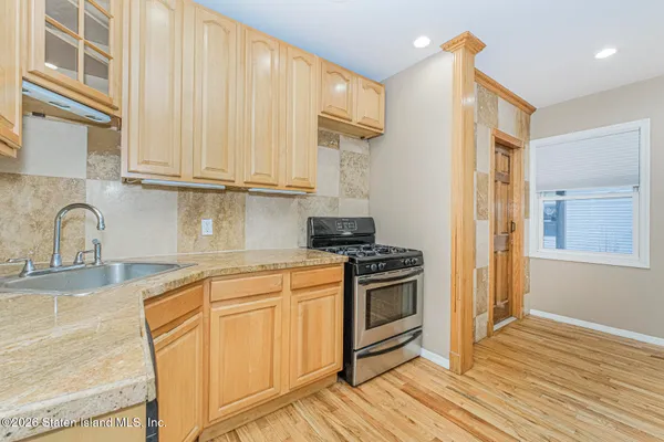 a kitchen with stainless steel appliances granite countertop a stove a sink and a refrigerator