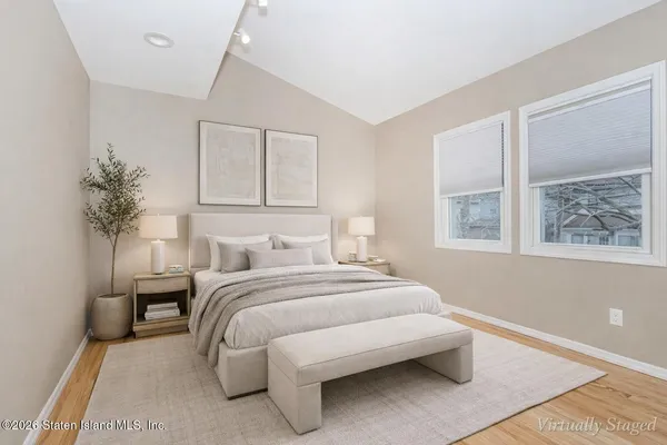 a bedroom with a large bed and a potted plant