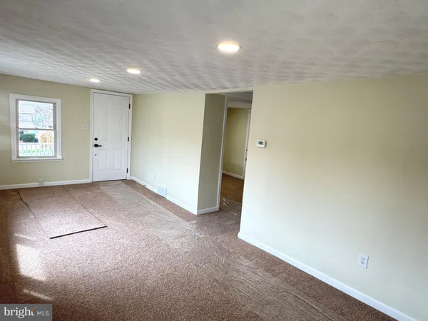a view of a hallway with wooden floor and entryway