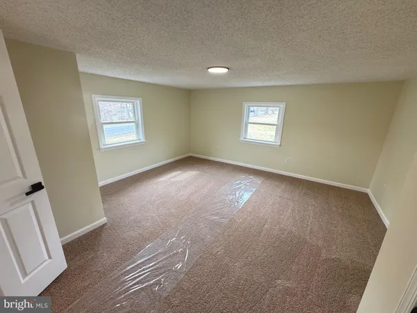 a view of a room that has wooden floor and brick walls