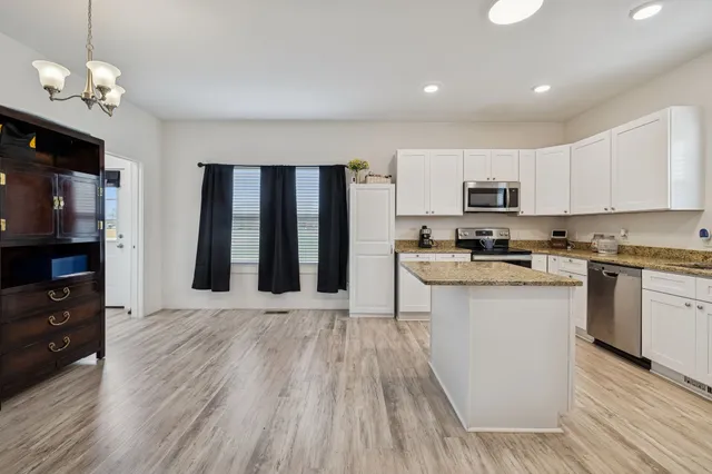 a kitchen with white cabinets and stainless steel appliances