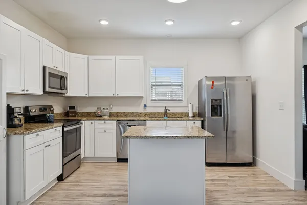 a kitchen with stainless steel appliances granite countertop a sink stove and refrigerator
