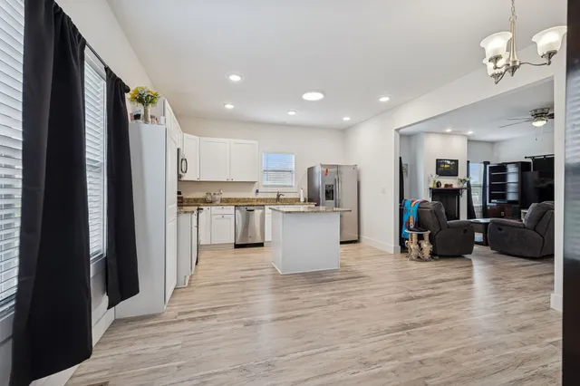 a view of kitchen with stainless steel appliances refrigerator oven microwave and furniture