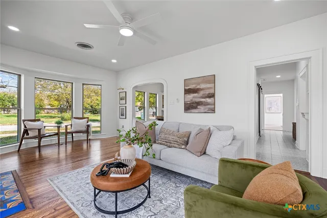 a living room with furniture a rug and a large window