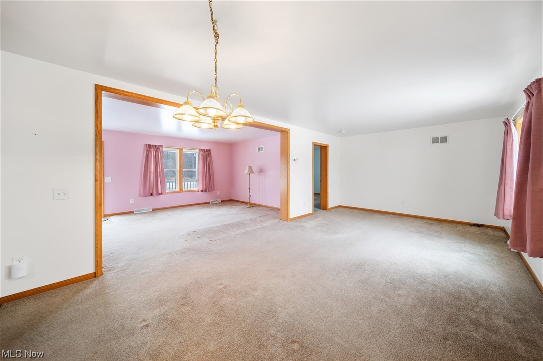 6037 Gerald Road Ashtabula, OH 44004 - Photo 9 of 34 Spare room featuring an inviting chandelier and light carpet