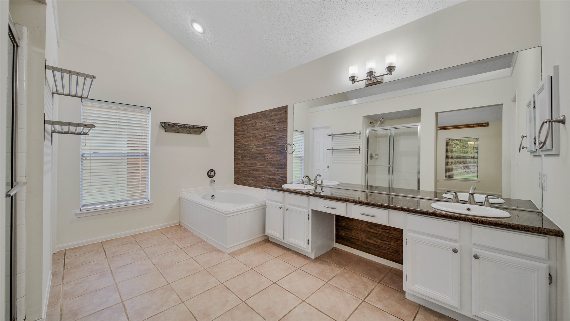 8826 Sunny Point Drive Spring, TX 77379 - Photo 14 of 16 a large bathroom with a granite countertop double vanity sink a mirror and a bathtub