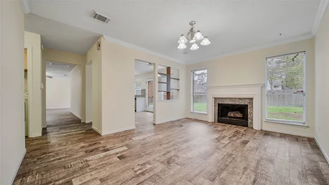 a view of a livingroom with a fireplace wooden floor and chandelier