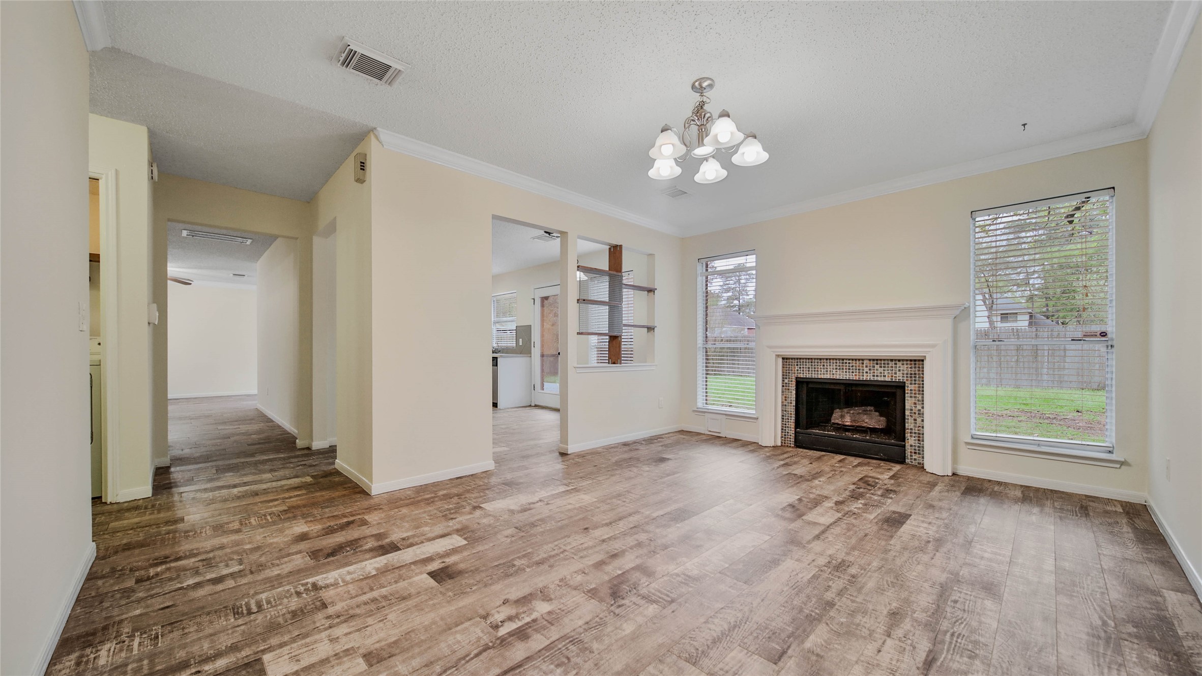 8826 Sunny Point Drive Spring, TX 77379 - Photo 6 of 16 a view of a livingroom with a fireplace wooden floor and chandelier