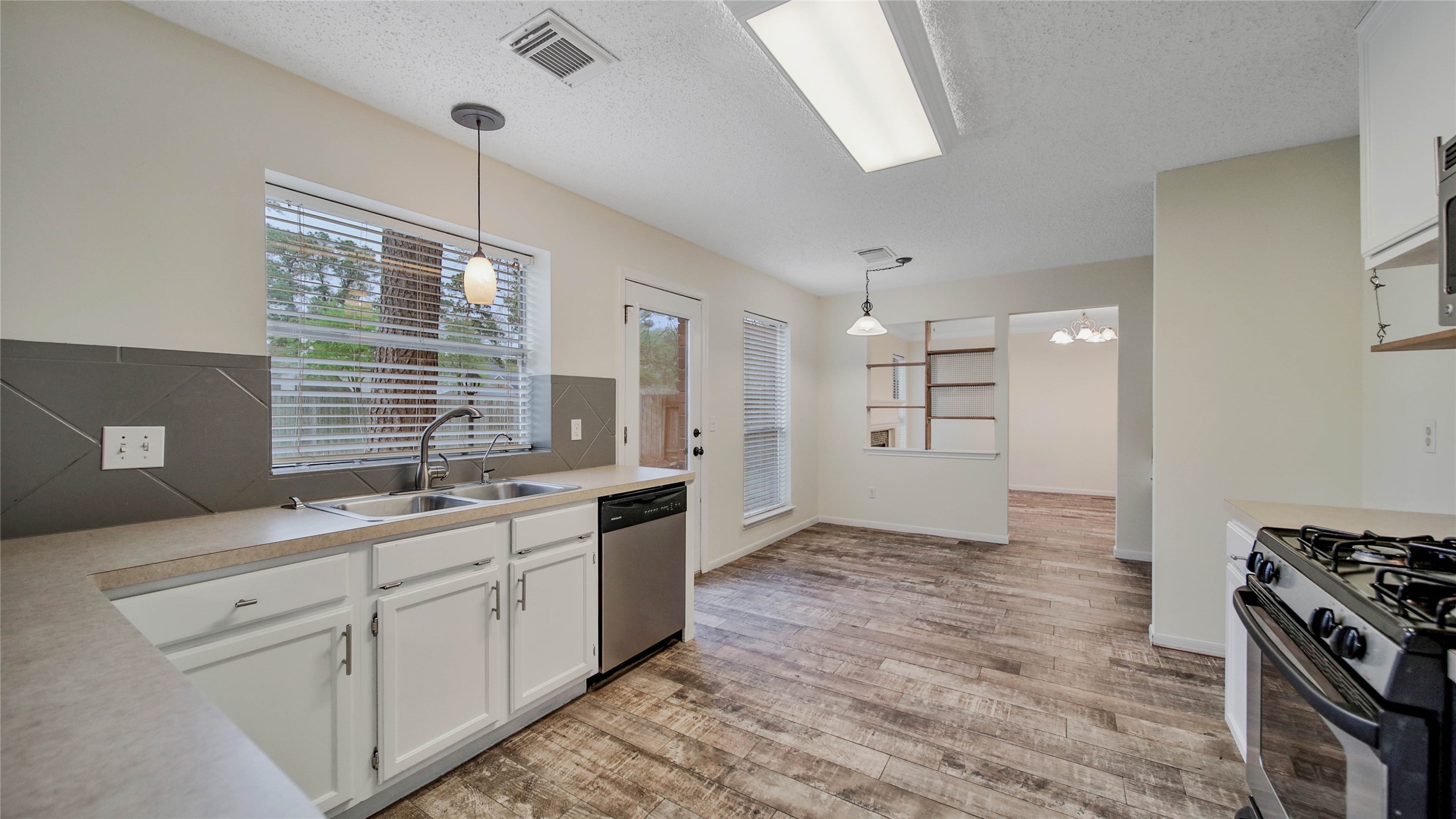 8826 Sunny Point Drive Spring, TX 77379 - Photo 8 of 16 a kitchen with stainless steel appliances granite countertop a sink stove and refrigerator