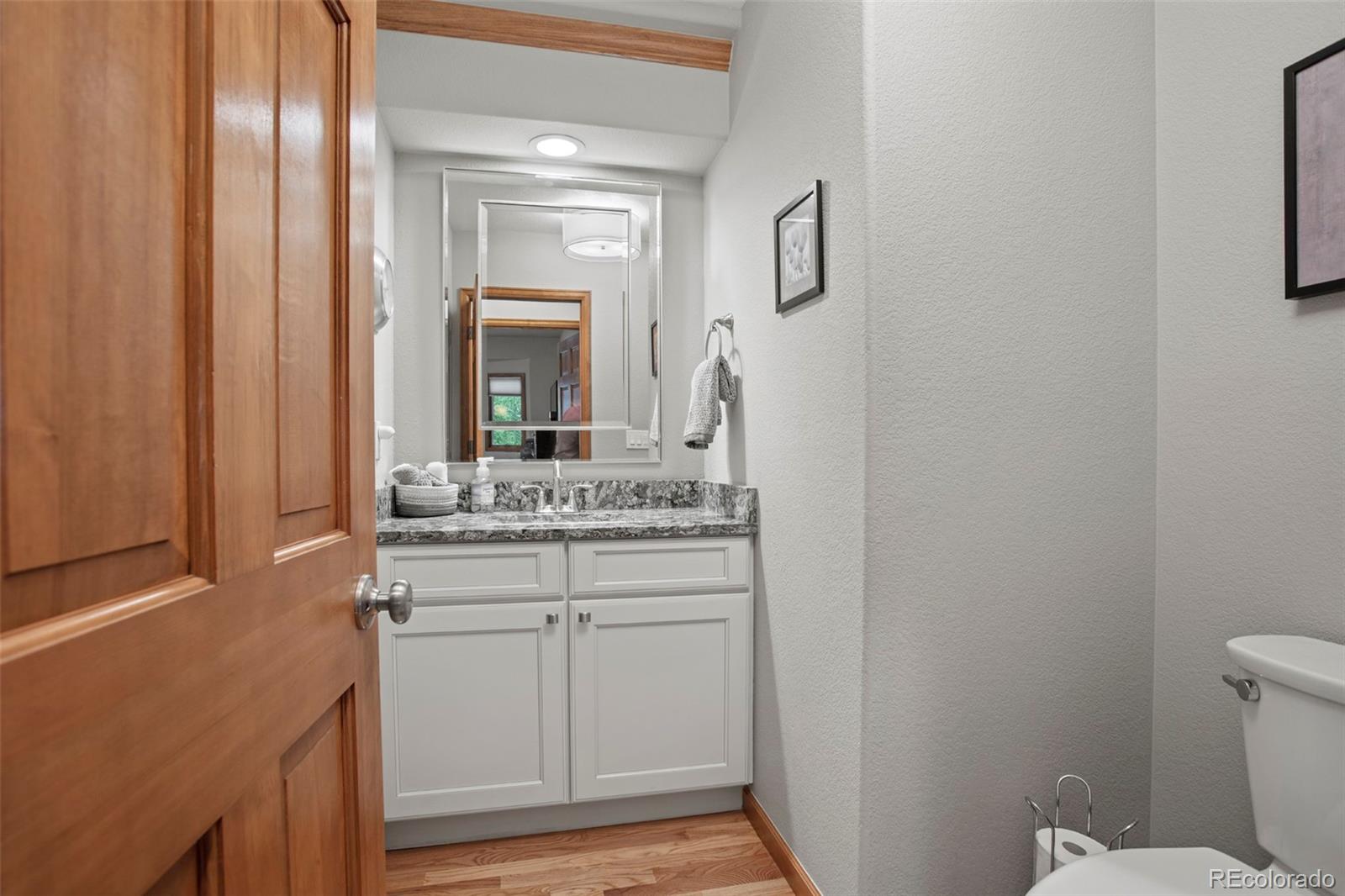 5703 Fig Way Arvada, CO 80002 - Photo 21 of 40 a bathroom with a granite countertop sink vanity and mirror