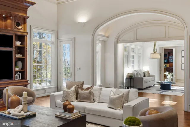a living room with furniture and floor to ceiling windows