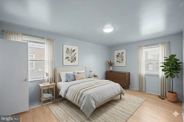 a bedroom with a large bed and a potted plant