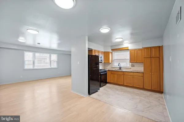 a kitchen with stainless steel appliances kitchen island granite countertop a stove a sink and a refrigerator
