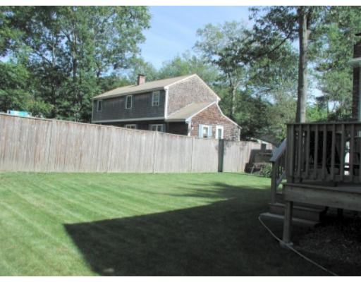37 Clover Road Holbrook, MA 02343 - Photo 2 of 8 a view of a backyard with wooden fence and trees
