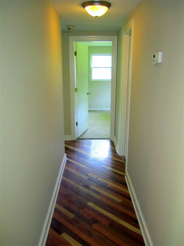 5576 Buckner Road Bumpass, VA 23024 - Photo 3 of 12 a view of a hallway with wooden floor and a bathroom