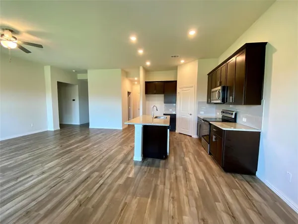 a large kitchen with stainless steel appliances granite countertop a large counter top a stove and a refrigerator