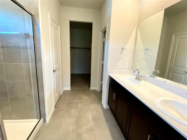 a bathroom with a double vanity sink a mirror and a shower