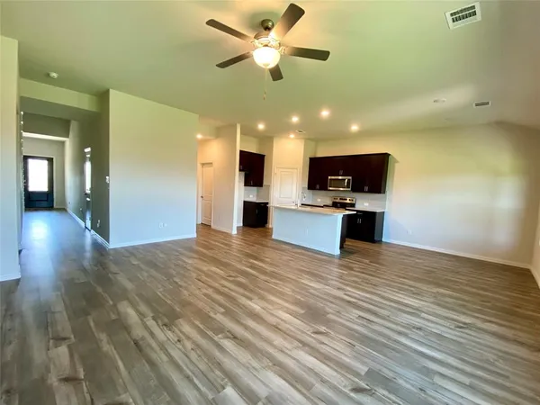 a view of kitchen with microwave a stove cabinets and wooden floor
