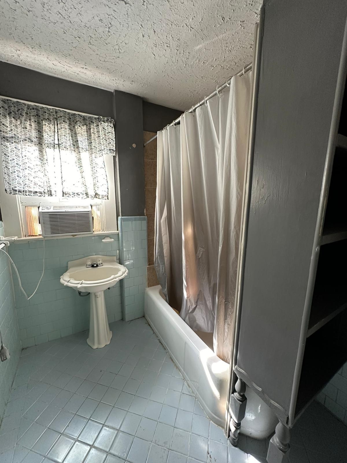 6818 Stearns Street Houston, TX 77021 - Photo 13 of 17 Clean and bright upstairs bathroom with a shower/tub combo and tiled surround