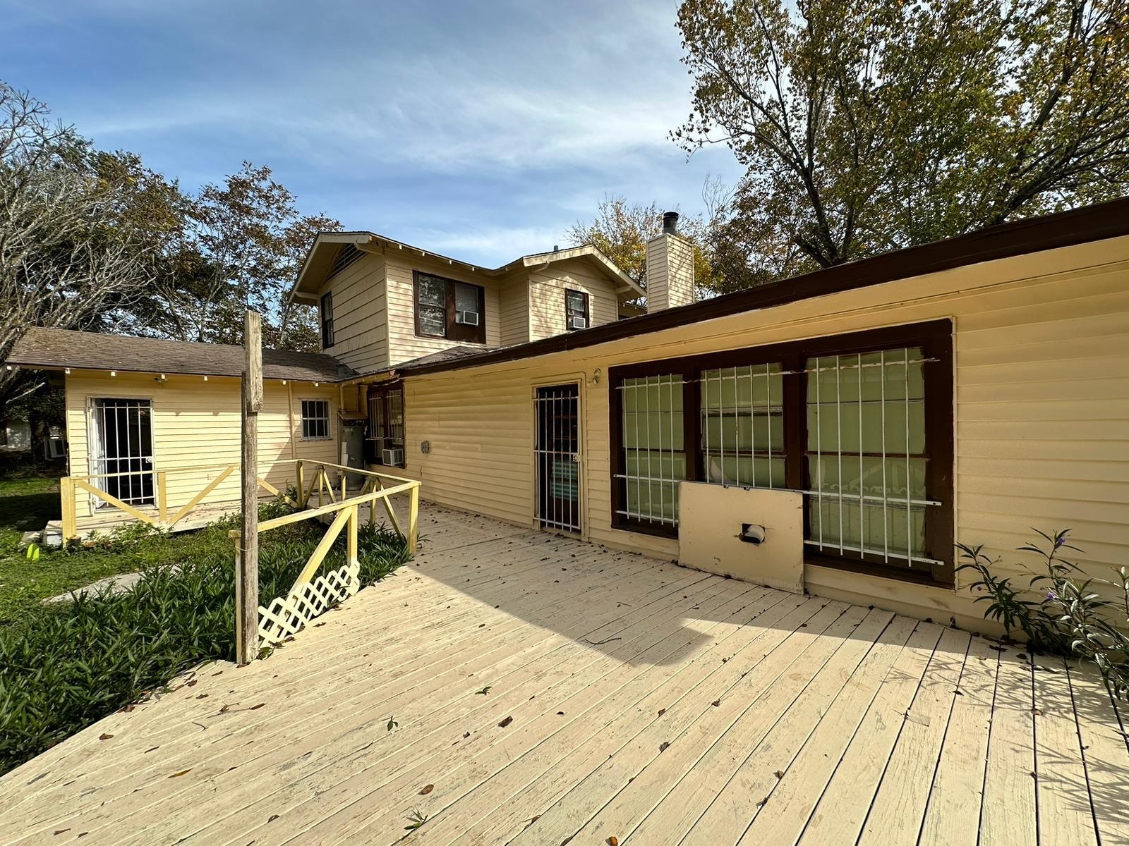 6818 Stearns Street Houston, TX 77021 - Photo 15 of 17 View of the home's rear exterior showcasing the private patio and mature landscaping