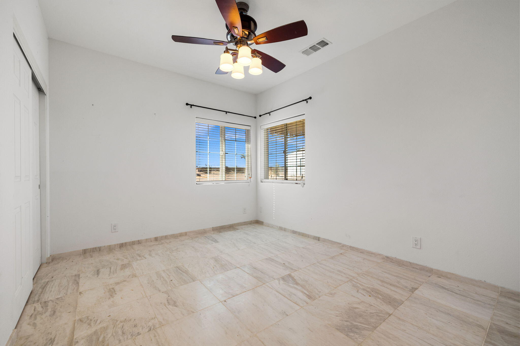 62734 Starlight Street Joshua Tree, CA 92252 - Photo 38 of 60 an empty room with a chandelier fan and windows