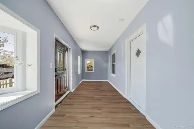 a view of a hallway with wooden floor and windows