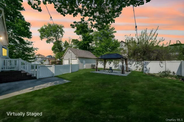 a view of a backyard with table and chairs plants and wooden fence