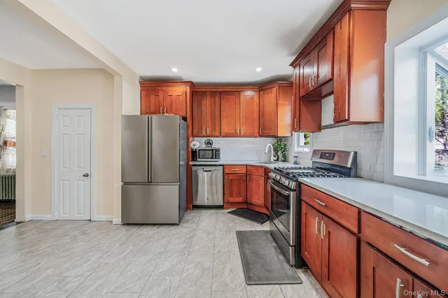 a kitchen with stainless steel appliances granite countertop a refrigerator stove top oven and sink