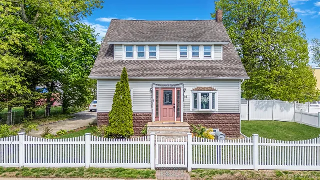 a front view of a house with a garden and plants