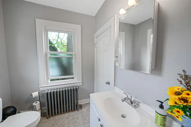 a bathroom with a sink a toilet and a window