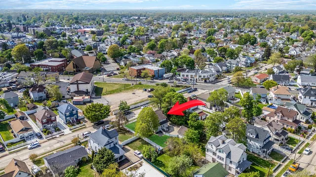 an aerial view of residential houses with outdoor space and trees