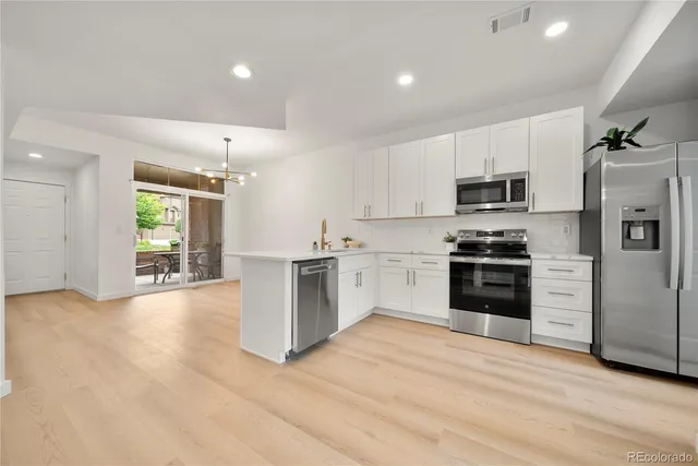 a kitchen with a refrigerator and a stove top oven