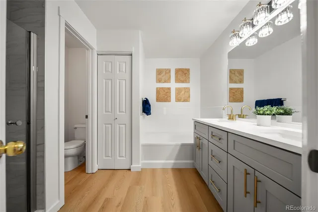 a spacious bathroom with a double vanity sink a large mirror a shower and a bathtub