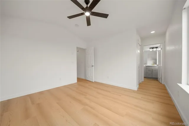 a view of a big room with wooden floor and a ceiling fan