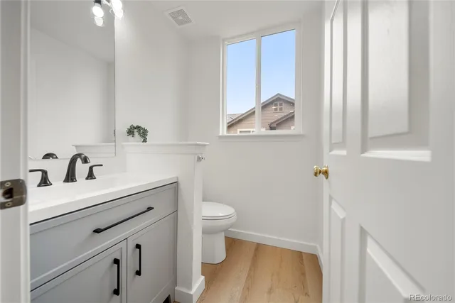 a bathroom with a sink a toilet and a window