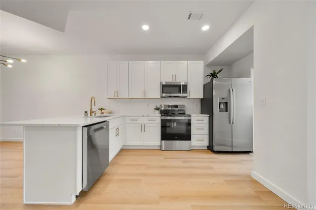 a kitchen with white cabinets and stainless steel appliances