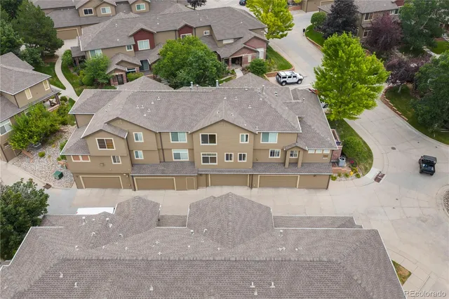 a aerial view of a house with a yard and large trees