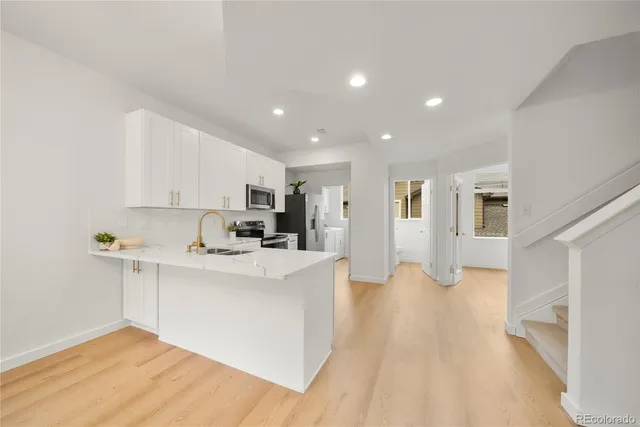 a view of kitchen with stainless steel appliances refrigerator oven and cabinets