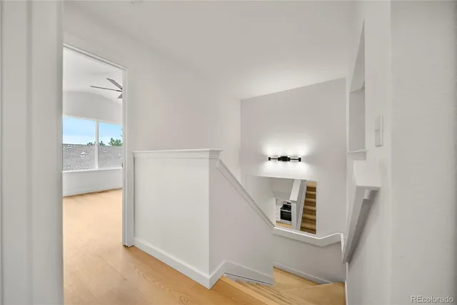 a view of a livingroom with wooden floor and a bathroom