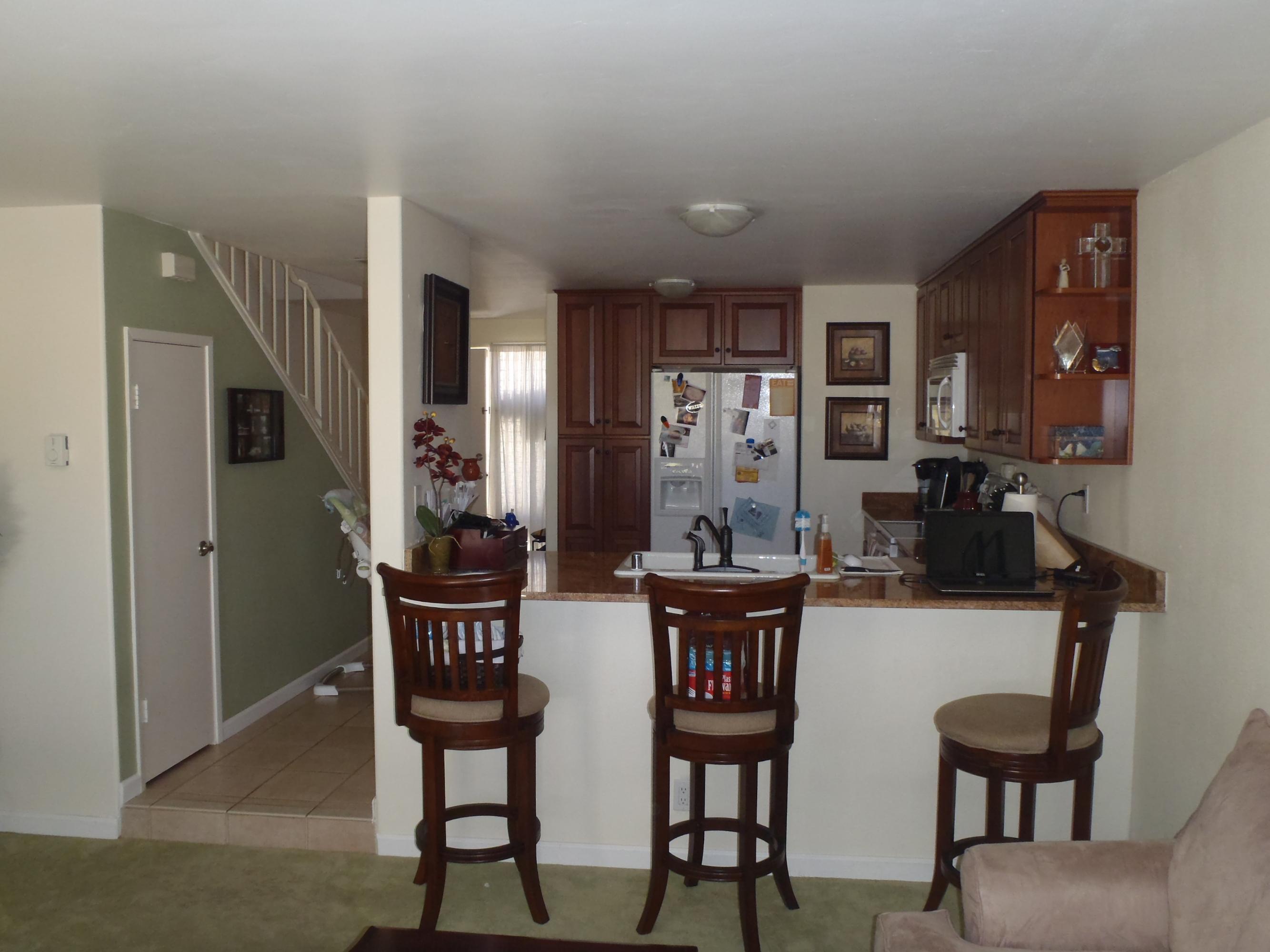 538 Mills Way Goleta, CA 93117 - Photo 3 of 17 a kitchen with stainless steel appliances kitchen island granite countertop a dining table chairs and a refrigerator