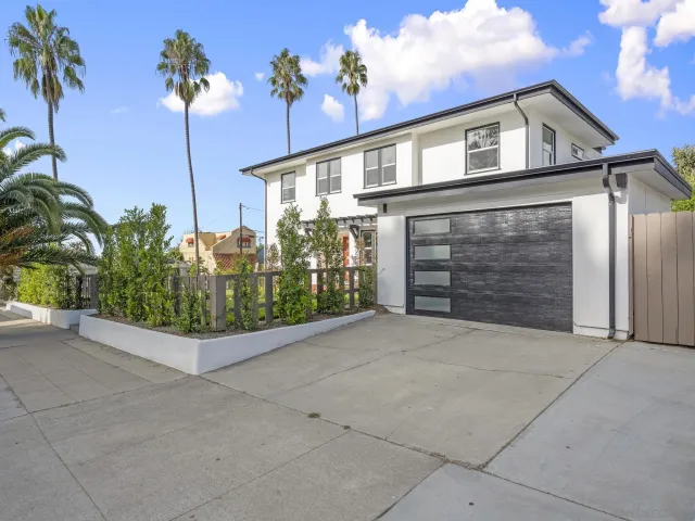 a front view of a house with plants