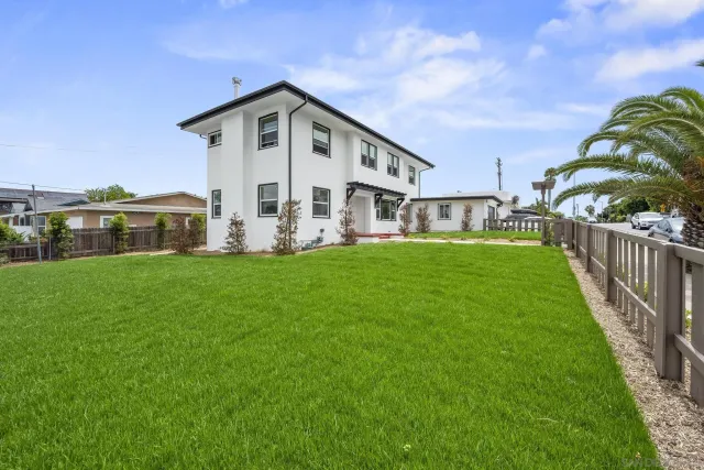 a front view of a house with a garden and plants
