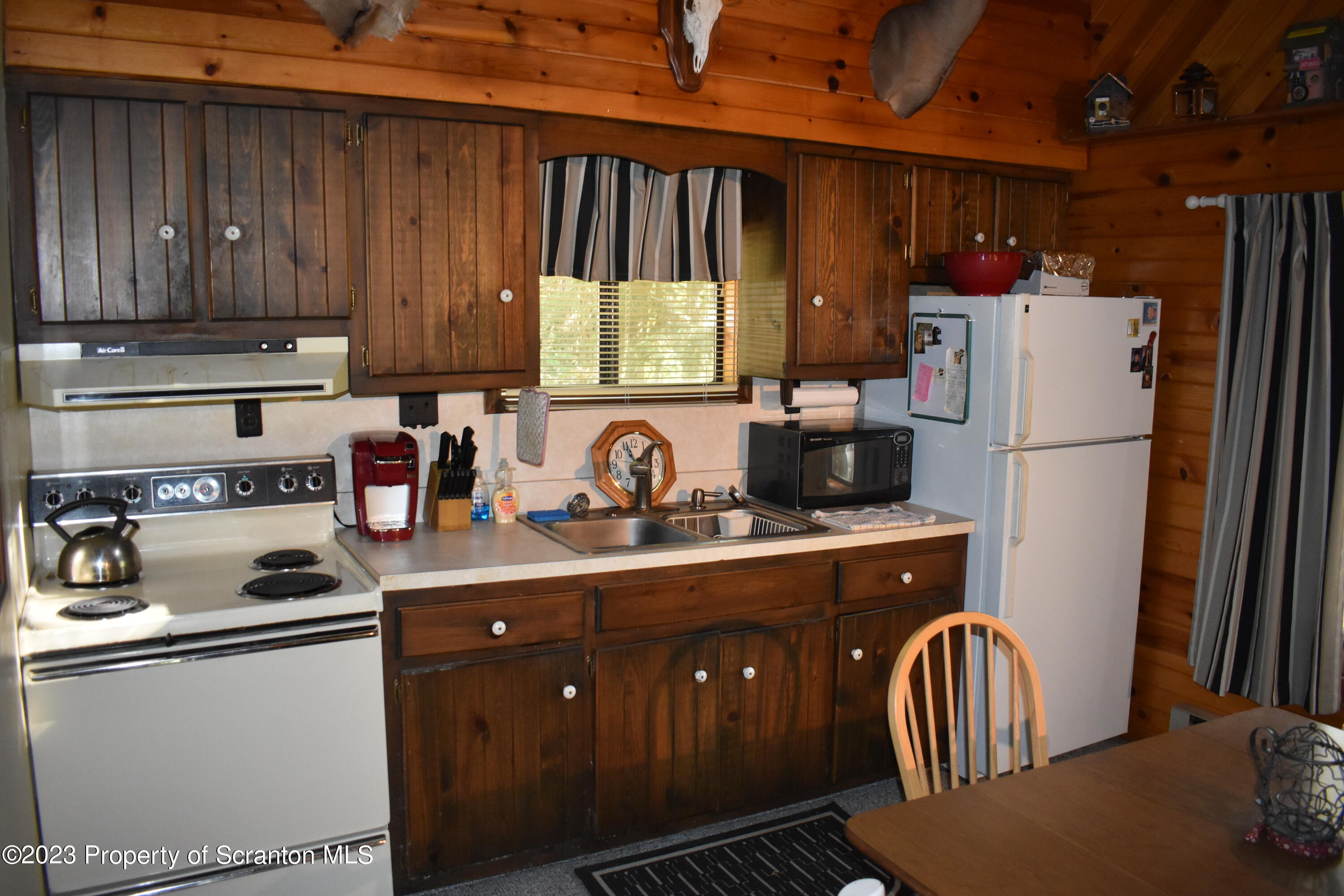 547 Camp Road New Milford, PA 18834 - Photo 9 of 27 a kitchen with wooden cabinets and white appliances