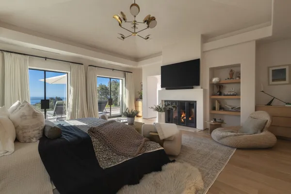 a bedroom with a bed and large window with balcony view