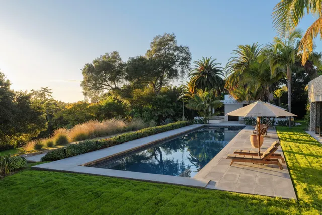 a view of a house with a yard and palm trees