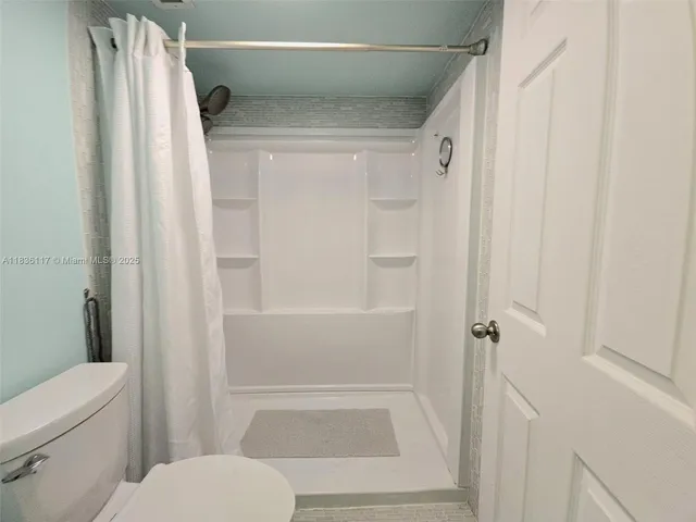 a bathroom with a shower and a toilet